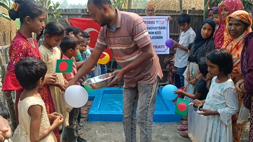Bangladeş'te su kuyusundan temiz su alan çocuklar